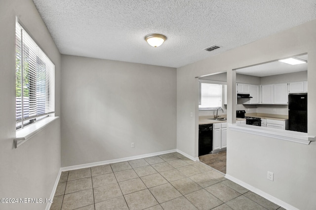 kitchen featuring a healthy amount of sunlight, white cabinetry, sink, and black appliances