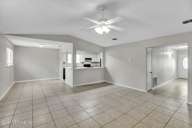 unfurnished living room featuring ceiling fan, light tile patterned floors, and a wealth of natural light