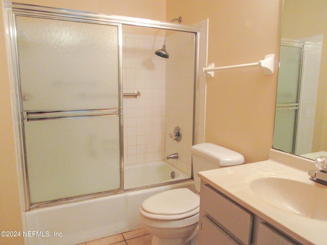 full bathroom featuring tile patterned floors, vanity, toilet, and enclosed tub / shower combo