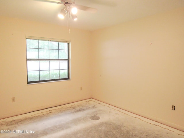 empty room with ceiling fan and concrete flooring