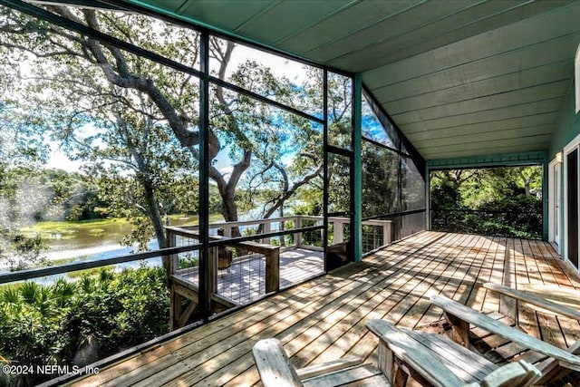 unfurnished sunroom with vaulted ceiling and a water view