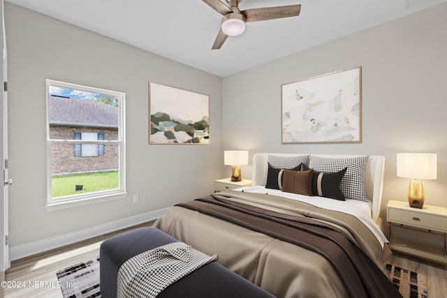 bedroom with a ceiling fan, baseboards, and wood finished floors