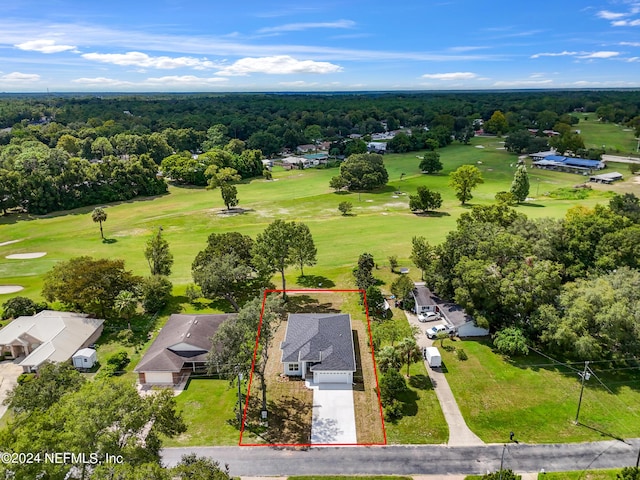 aerial view featuring golf course view and a wooded view