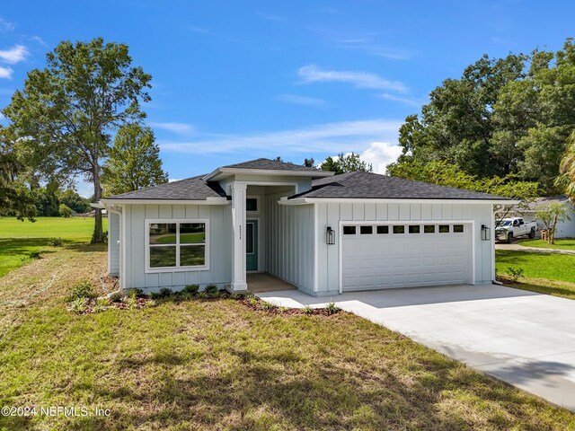 view of front of home with a front yard and a garage