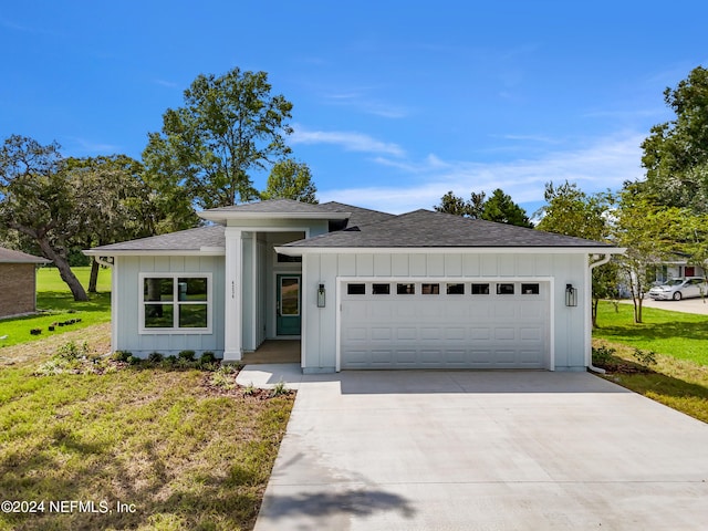 view of front of home with a garage and a front lawn