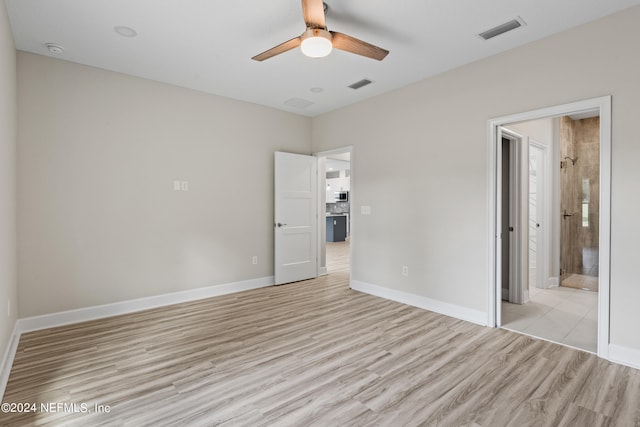 unfurnished bedroom featuring light wood-type flooring, baseboards, visible vents, and connected bathroom