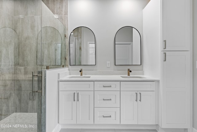 bathroom with double vanity, a sink, and a shower stall