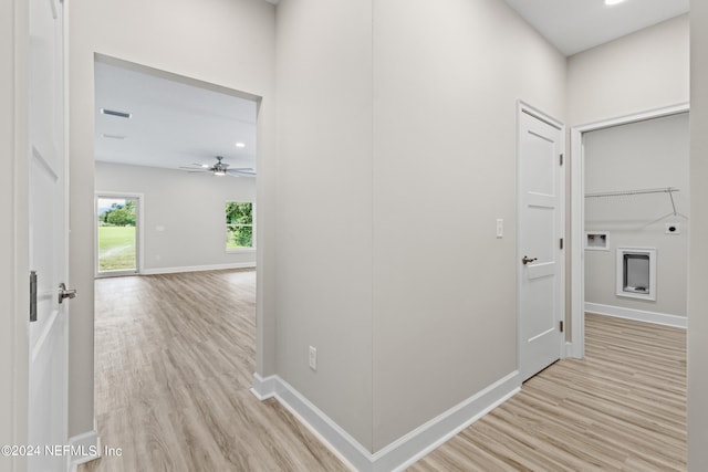 corridor featuring light wood-style floors, visible vents, and baseboards