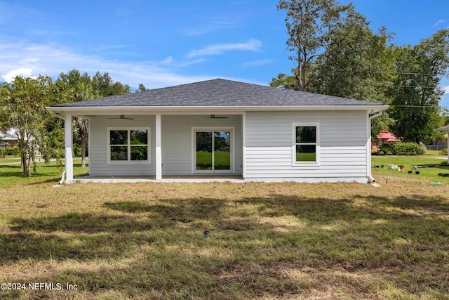 back of house featuring a patio area, roof with shingles, a ceiling fan, and a yard