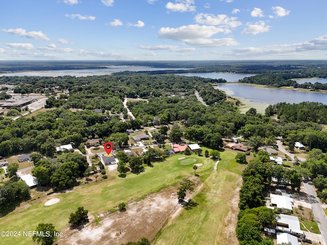 birds eye view of property featuring a water view and a wooded view