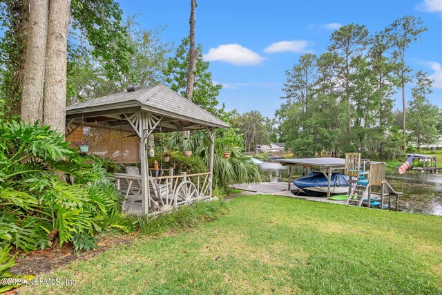 view of yard with a boat dock and a water view