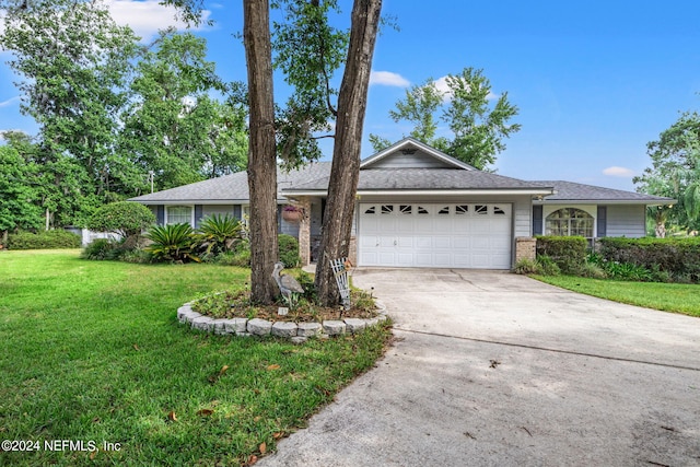 ranch-style home with an attached garage, brick siding, concrete driveway, and a front yard