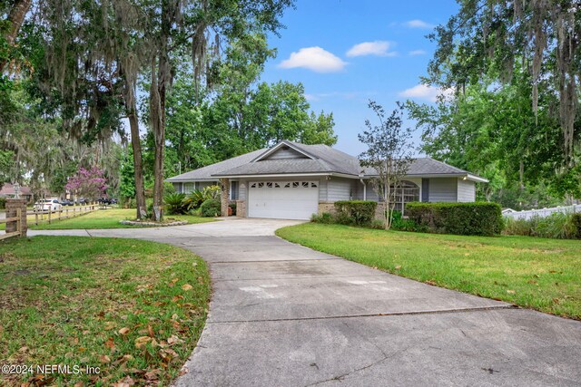 ranch-style home with a garage and a front lawn