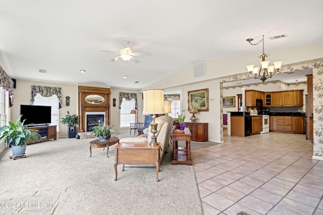 living room with lofted ceiling, light tile patterned floors, visible vents, and a glass covered fireplace