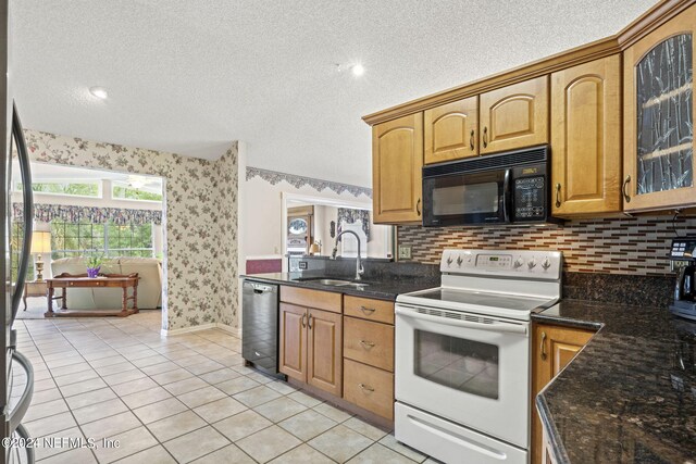 kitchen with white range with electric cooktop, a sink, black microwave, dishwasher, and wallpapered walls