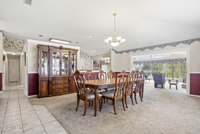 tiled dining area with a notable chandelier, vaulted ceiling, and a textured ceiling