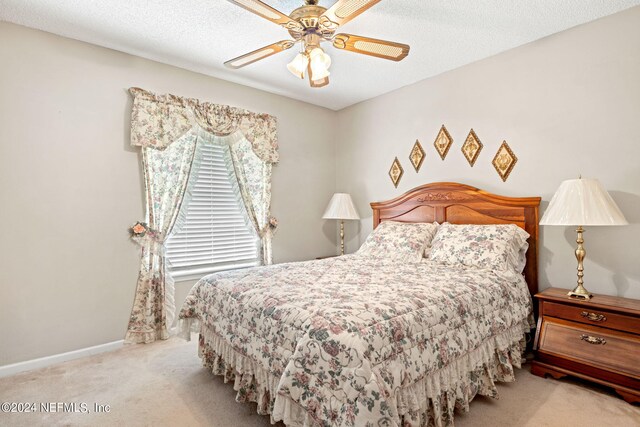 bedroom with a textured ceiling, carpet floors, and ceiling fan