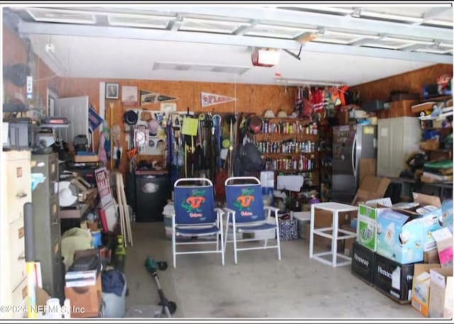 garage featuring a garage door opener and freestanding refrigerator