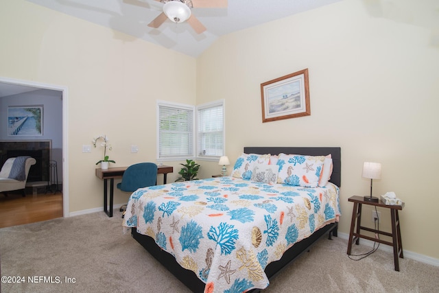 bedroom with ceiling fan, light colored carpet, and vaulted ceiling