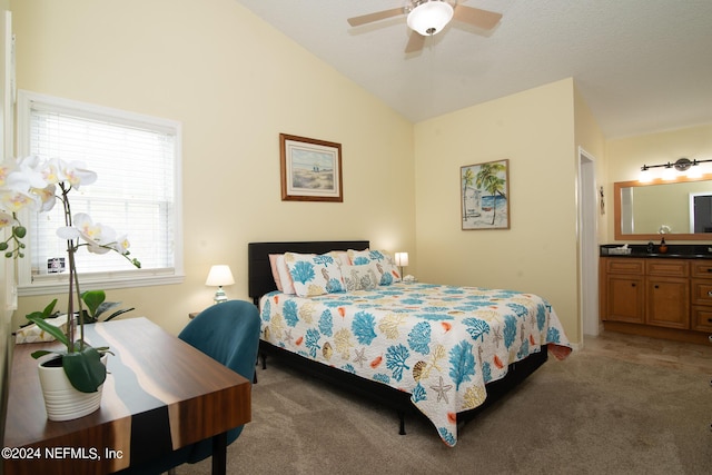 bedroom featuring dark colored carpet, ceiling fan, lofted ceiling, and connected bathroom