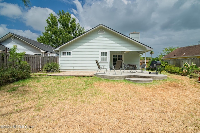 back of property with a yard and a patio