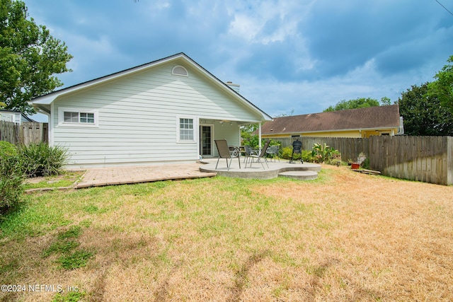 rear view of property with a lawn and a patio area