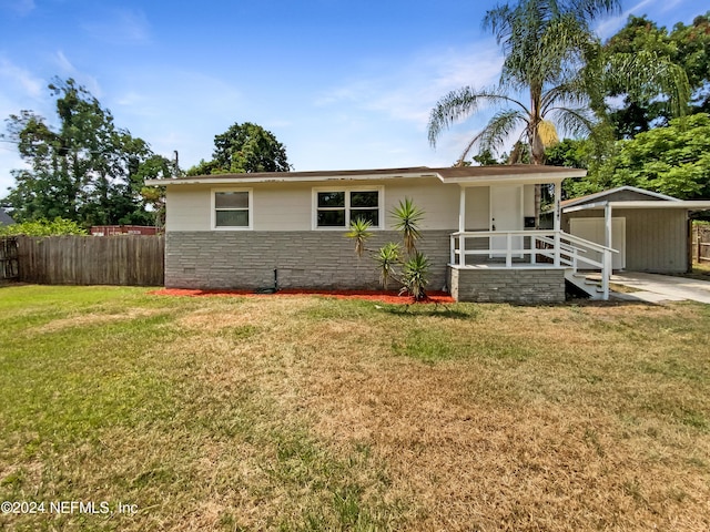 view of front of home featuring a front yard and a storage shed