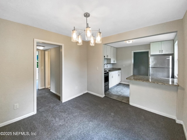 kitchen with baseboards, freestanding refrigerator, an inviting chandelier, white cabinetry, and dark colored carpet