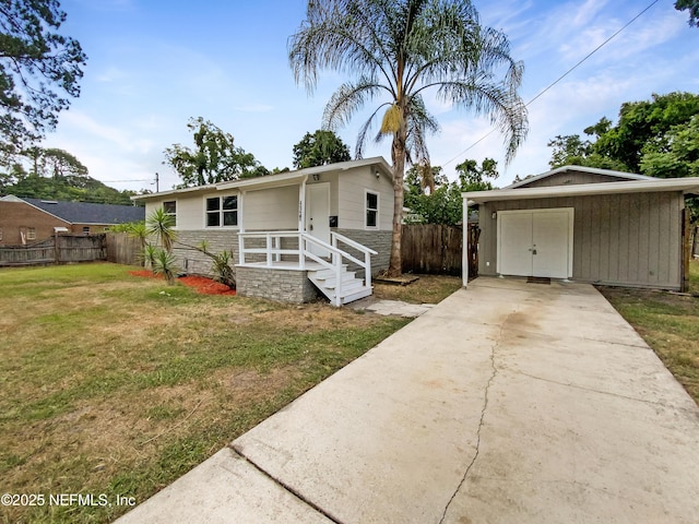 view of front of house with fence, concrete driveway, a front yard, a garage, and stone siding