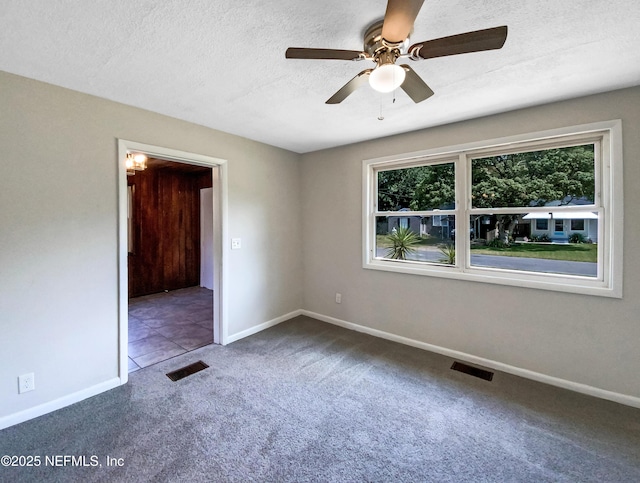 unfurnished room featuring visible vents, a textured ceiling, baseboards, and carpet floors