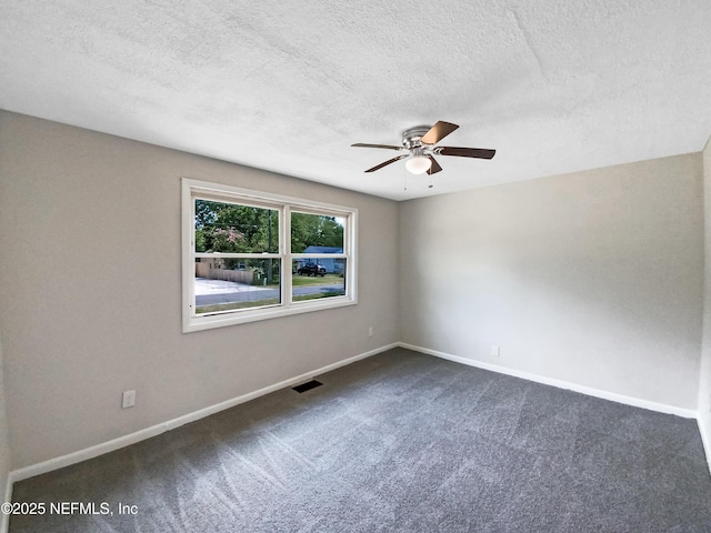 unfurnished room with baseboards, visible vents, dark carpet, and ceiling fan