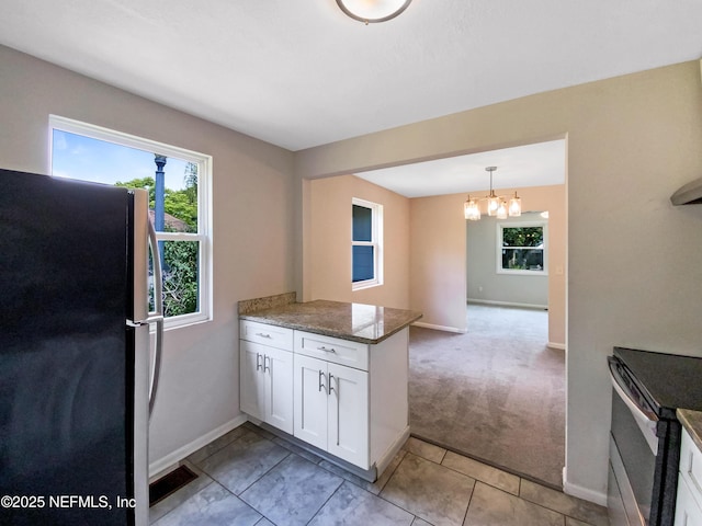 kitchen featuring a wealth of natural light, white cabinetry, a peninsula, and stainless steel appliances