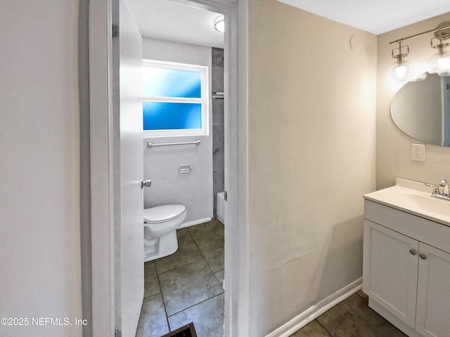 bathroom featuring vanity, toilet, baseboards, and tile patterned flooring