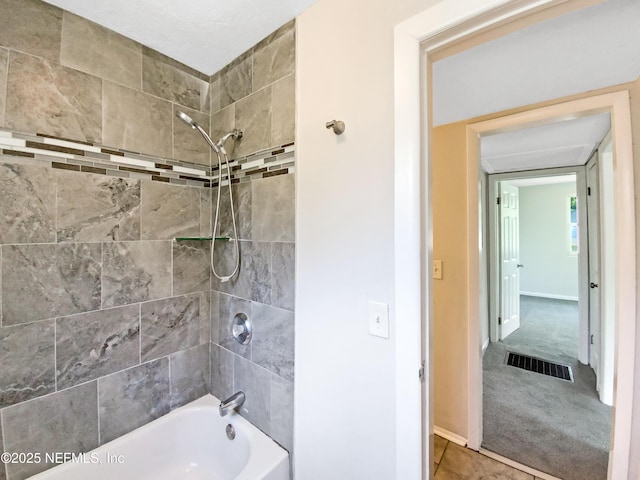 bathroom featuring visible vents, baseboards, and  shower combination