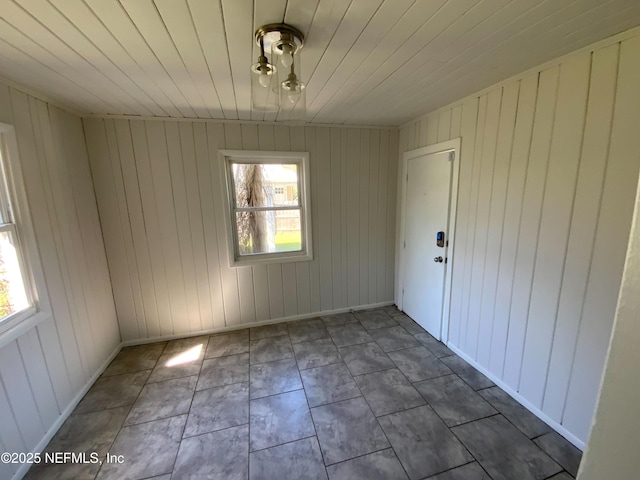 unfurnished room featuring wooden ceiling, baseboards, and a wealth of natural light