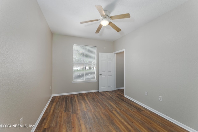 empty room featuring dark hardwood / wood-style flooring and ceiling fan