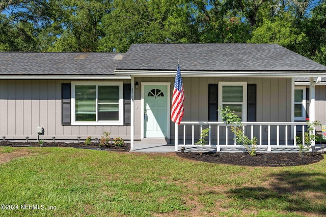 ranch-style home featuring a porch and a front yard