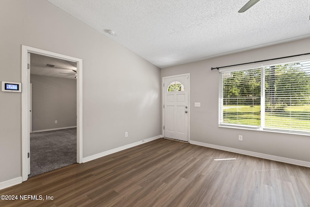 foyer featuring hardwood / wood-style floors, a textured ceiling, and vaulted ceiling