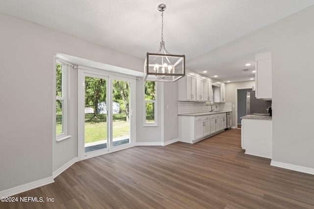 kitchen with decorative backsplash, sink, pendant lighting, dark hardwood / wood-style floors, and white cabinetry