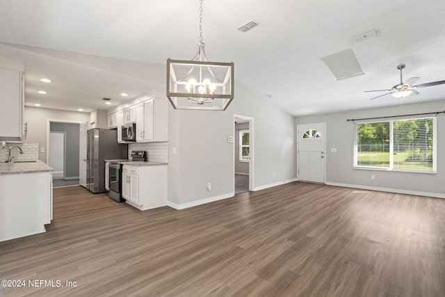 kitchen featuring white cabinetry, sink, backsplash, vaulted ceiling, and appliances with stainless steel finishes