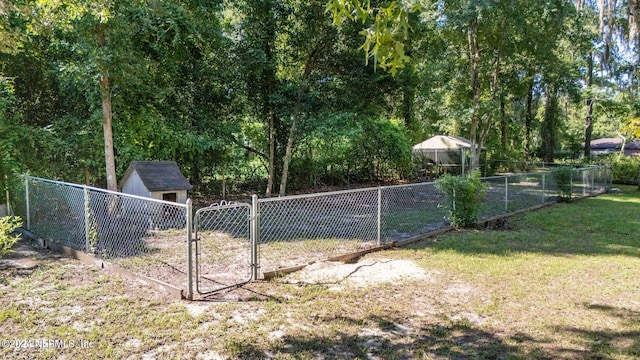 view of gate with a yard and a storage shed