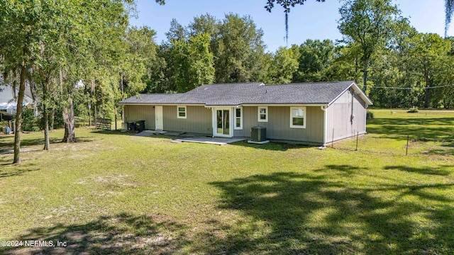 rear view of house with a lawn and cooling unit