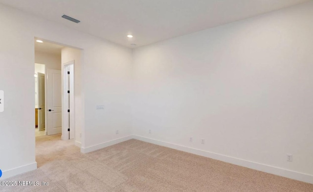 empty room featuring light carpet, recessed lighting, visible vents, and baseboards