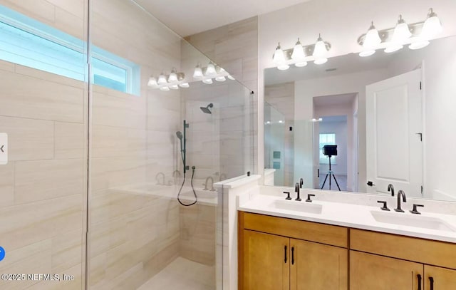 full bathroom with a stall shower, a sink, and double vanity