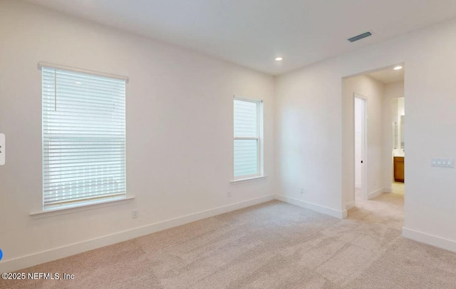 empty room with carpet floors, recessed lighting, a wealth of natural light, and baseboards