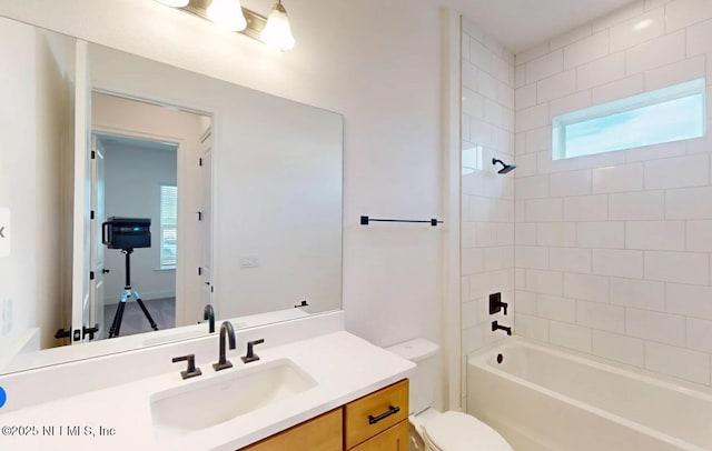 bathroom with washtub / shower combination, vanity, and toilet