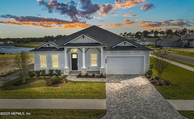 view of front of home with a garage and a lawn