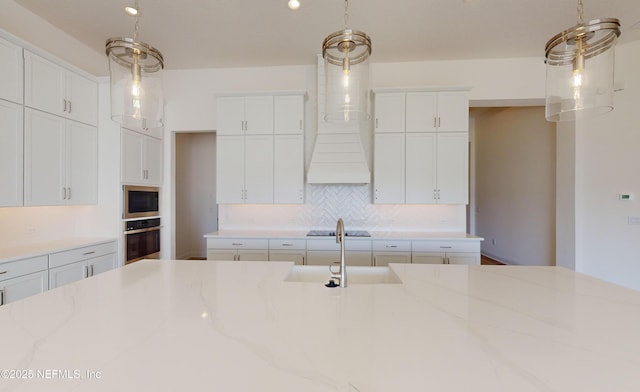 kitchen with stainless steel oven, sink, light stone countertops, built in microwave, and white cabinetry