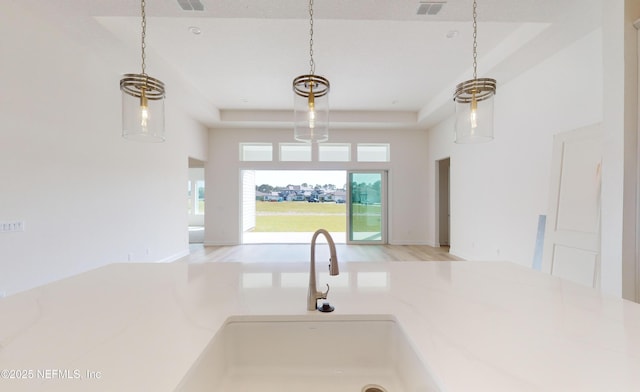 kitchen featuring light hardwood / wood-style floors, a towering ceiling, and a tray ceiling