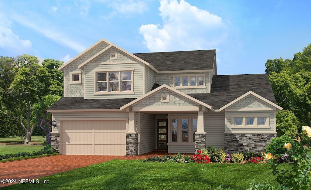 view of front of home featuring an attached garage, stone siding, a front lawn, and decorative driveway